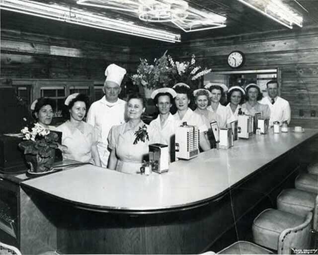 A group of people standing behind a counter.