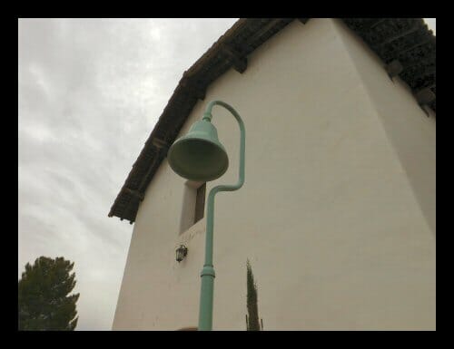 An El Camino Real marker bell in front of Mission San Miguel in San Luis Obispo County